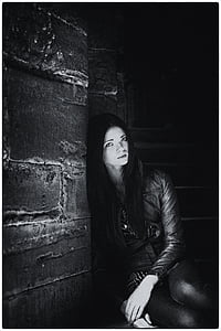 grayscale photo of woman leaning on gray wall thumbnail