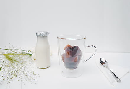 glass mug beside spoon on table thumbnail