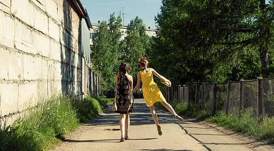 woman in sleeveless dress beside woman in black dresses thumbnail