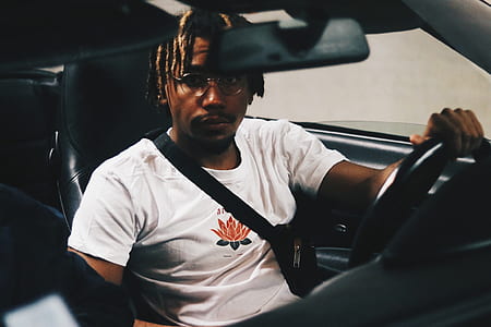 man sitting in driver's seat while in black seat belt thumbnail