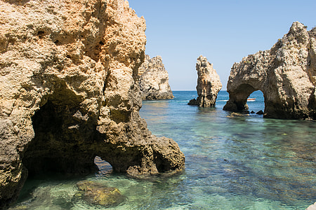 natural arch rock formations on body of water thumbnail