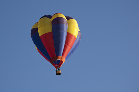 red, blue, and yellow hot air balloon flying thumbnail