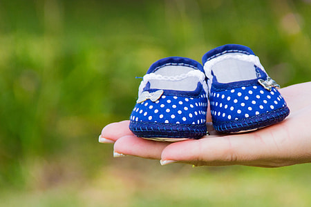 person holding girl's white-and-blue polka dot flat shoes thumbnail