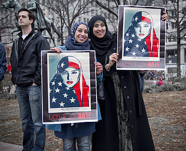 two women holding Love Hate posters thumbnail