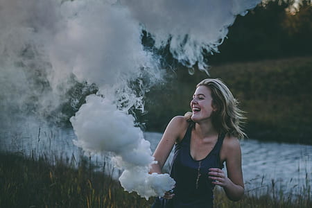 woman using vape at grass field during thumbnail