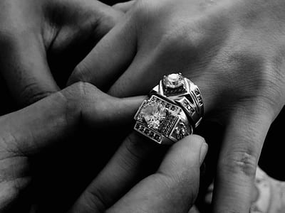 Grayscale Photo of Person Wearing Two Diamond-encrusted Rings thumbnail