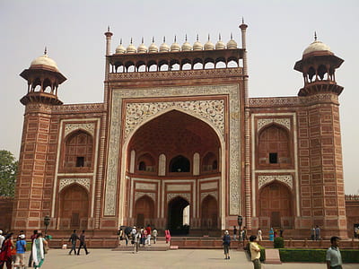 brown concrete mosque surrounded by people thumbnail