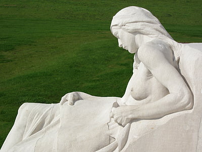 statue of sitting woman surrounded by green grass thumbnail