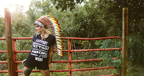 photo of woman in black t-shirt standing on front of fence thumbnail