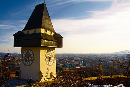 beige and brown painted house with clock over city thumbnail