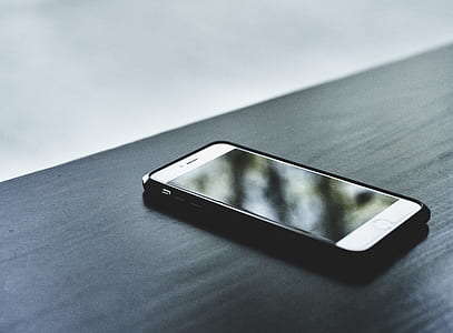 silver iPhone 6 and black case on black wooden top thumbnail
