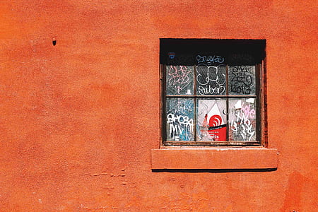 orange painted wall with window taken at daytime thumbnail