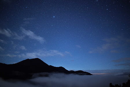 silhouette of mountain under starry night thumbnail