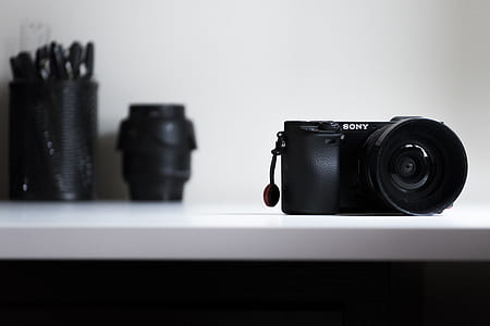 black Sony DSLR camera on white table thumbnail