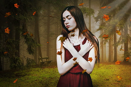 woman wearing red dress standing with falling leaves at forest thumbnail