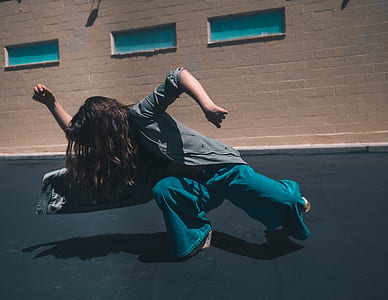woman dancing outdoor near brown concrete building during daytime thumbnail