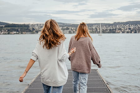 two women walking on dock during daytime thumbnail