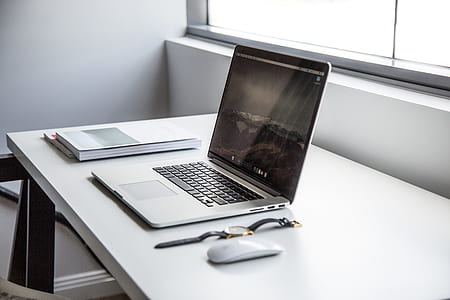 MacBook Pro with Magic Mouse on table thumbnail