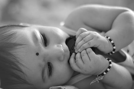 grayscale photo of baby eating chocolates thumbnail