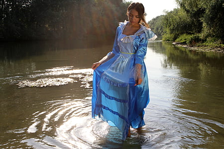 woman wearing blue square-neckline long-sleeved maxi dress standing on river thumbnail