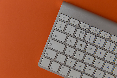 Apple wireless computer keyboard on orange background thumbnail