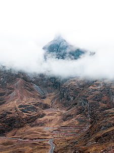 aerial photography of winding road leading to mountain thumbnail