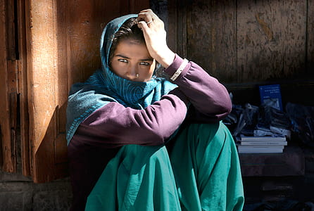 woman wearing green and purple dress sitting on chair thumbnail