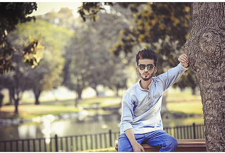 Man Sitting On Bench Beside Tree thumbnail