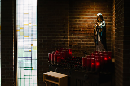 Mother Mary statuette near candle stand thumbnail