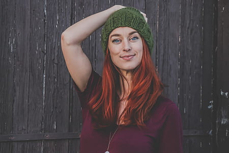 Red Haired Woman in Maroon Top Wearing Green Beanie thumbnail