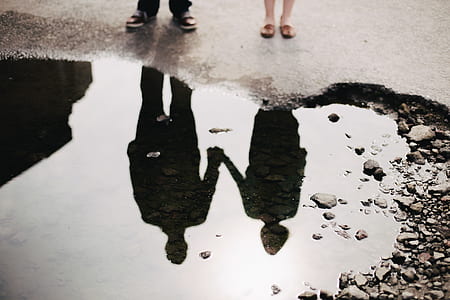 water reflection of couple holding hands together thumbnail
