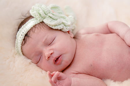 closeup photo of baby sleeping on white fur cushion thumbnail