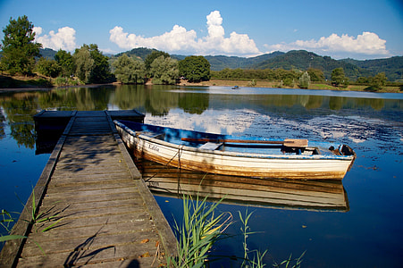 empty boat docked on a body of water thumbnail
