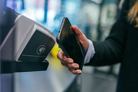 person holding black smartphone near scanner thumbnail