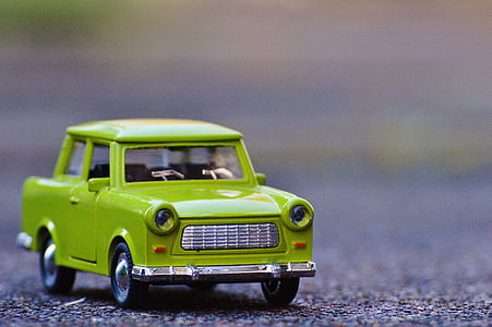 selective focus photography of green car die-cast metal model on concrete road at daytime thumbnail