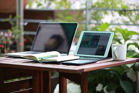 white tablet computer and computer keyboard on table near mug thumbnail