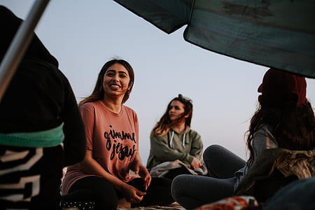 three female sitting near umbrella thumbnail