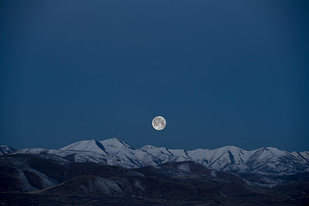 white and black high mountains under blue sky at full moon thumbnail