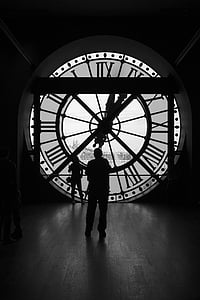 silhouette of two persons on front of clock thumbnail