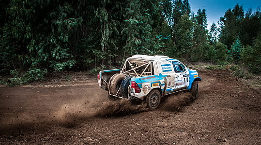White And Blue Pickup Truck Drifting On Curve Dirt Road thumbnail