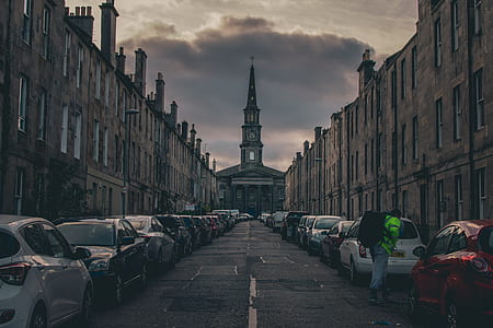 parked vehicles near brown buildings thumbnail