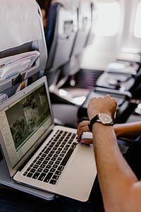 Unrecognizable man with notebook sitting inside an airplane thumbnail
