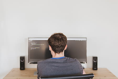 man sitting on chair infront of flat screen computer monitor thumbnail
