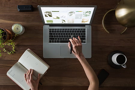 person using MacBook Pro and notebook thumbnail