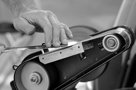 grayscale photography of person honing knife thumbnail