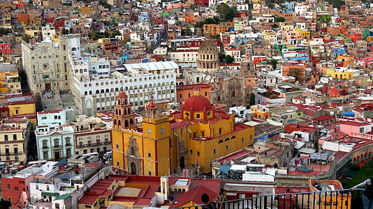 aerial photography of brown cathedral surrounded with high rise buildings thumbnail