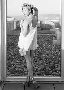 woman in lace camisole top standing near window thumbnail