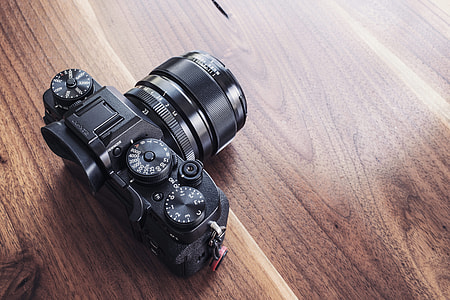 black dslr camera on brown wooden table thumbnail