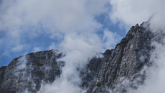 clouds surrounding gray rocky mountain thumbnail