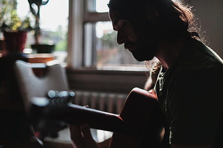 selective focus photo of man playing guitar thumbnail